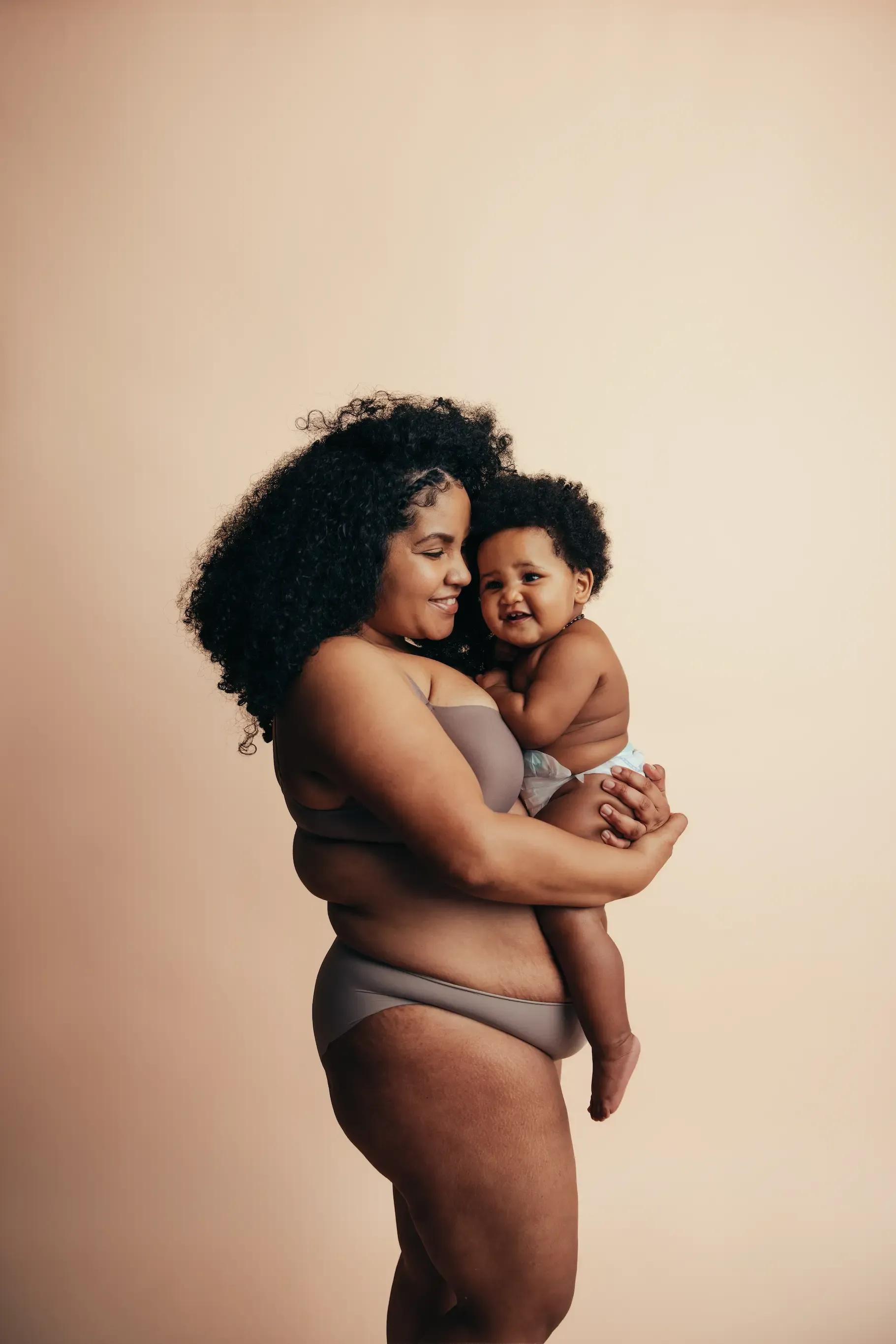 Mother gently holding her baby, reflecting love and the joy of early motherhood.